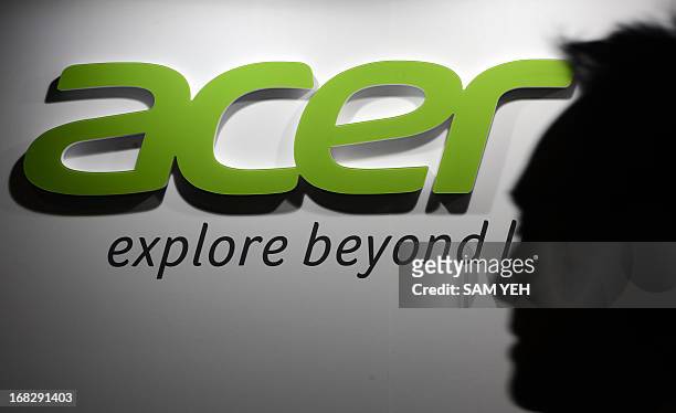An man walks past an Acer logo during the annual investors' conference in Taipei on May 8, 2013. Taiwan's leading personal computer maker Acer said...