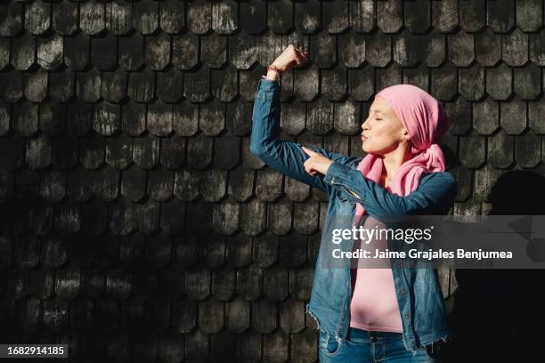 mujer con cáncer mostrando fuerza con los brazos al aire libre - best bosom fotografías e imágenes de stock