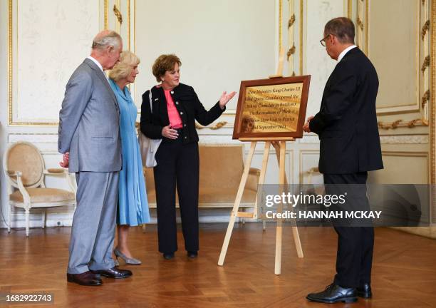 British Ambassador to France Menna Rawlings presents a plaque to Britain's King Charles III and his wife Queen Camilla during a visit to Bordeaux's...