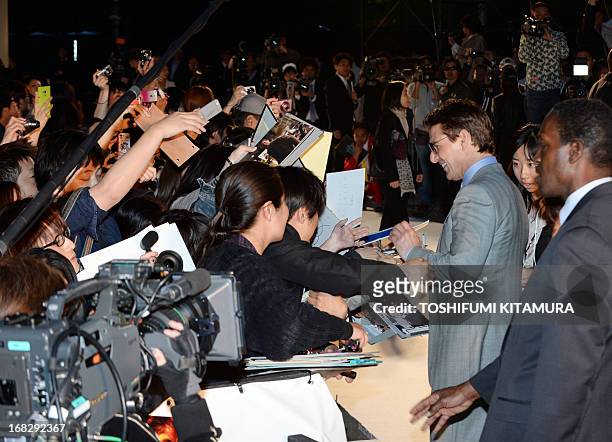 Actor Tom Cruise signs autographs to fans during his latest movie "Oblivion" Japan premier in Tokyo on May 8, 2013. The science fiction movie,...