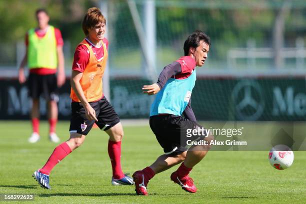 Shinji Okazaki is challenged by Gotoku Sakai during a VfB Stuttgart training session at the club's premises on May 8, 2013 in Stuttgart, Germany.
