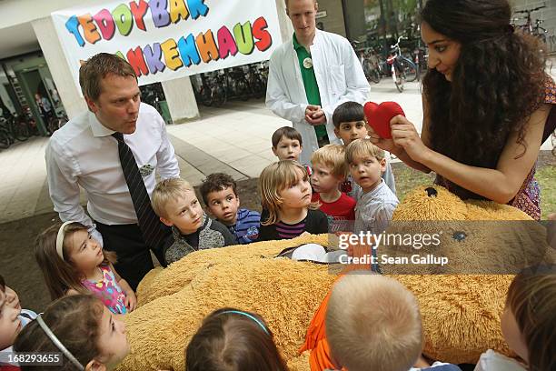 German Health Minister Daniel Bahr looks on as medical student Lisa Ridha explains the functions of a teddy bear's heart at the Teddy Bear Clinic at...