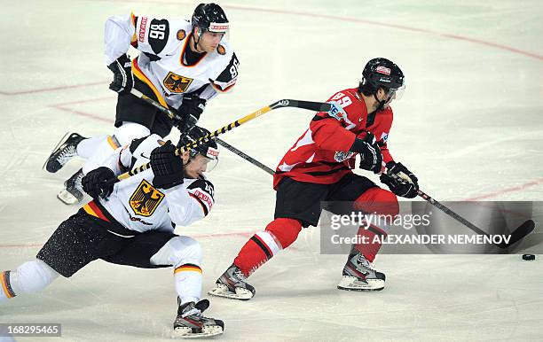 Germany's defender Frank Hordler and Germany's forward Daniel Pietta rush to get Ausria's forward Raphael Herburger during a preliminary round game...