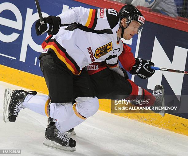 Germany's defender Christian Ehrhoff vies with Ausria's forward David Schuller during a preliminary round game Austria vs Germany of the IIHF...