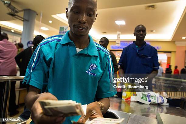 An employee counts Kenyan shilling notes at a cash desk inside the Nakumatt department store at Westgate Mall in Nairobi, Kenya, on Friday, May 3,...