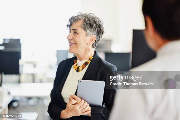 medium shot businesswoman in discussion during meeting in office - happy asian woman bright office stock-fotos und bilder