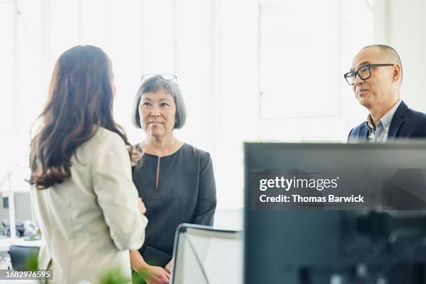 medium shot business colleagues discussing project in high tech office - halbnahe-einstellung stock-fotos und bilder