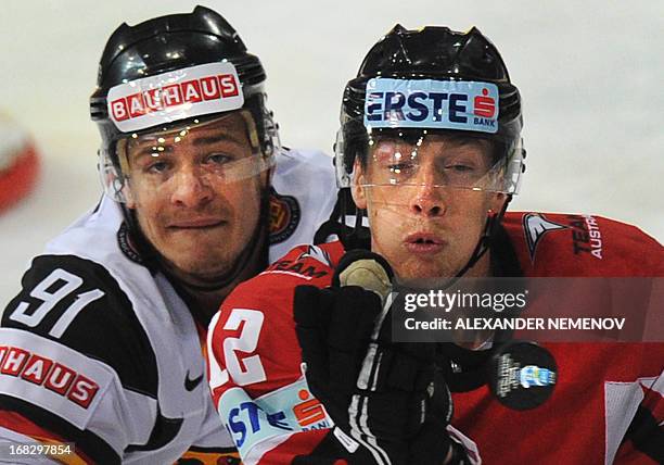 Germany's defender Moritz Muller vies with Austria's forward Michael Raffl during a preliminary round game Austria vs Germany of the IIHF...