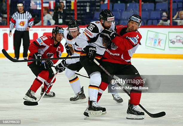 Gerhard Unterluggauer of Austria and Yannic Seidenberg of Germany battle for the puck during the IIHF World Championship group H match between...