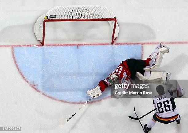 Berhard Starkbaum , goaltender of Austria makes a save on Daniel Pietta of Germany during the IIHF World Championship group H match between Austria...