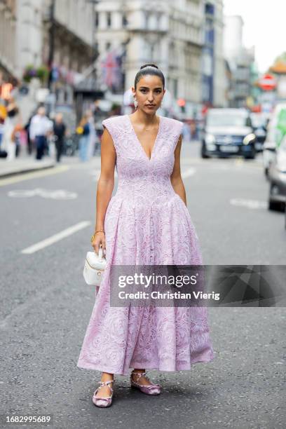 Bettina Looney wears pink sleeveless dress, white bag outside Huishan Zhang during London Fashion Week September 2023 on September 15, 2023 in...