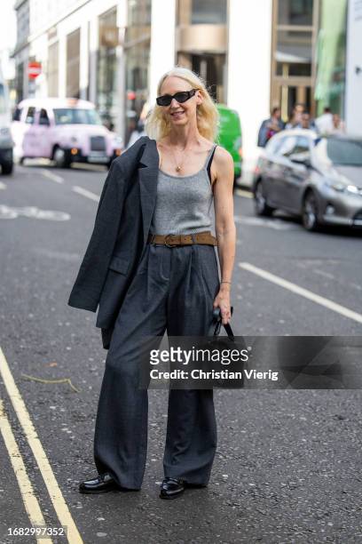 Guest wears grey top pants, blazer, black bag outside Huishan Zhang during London Fashion Week September 2023 on September 15, 2023 in London,...