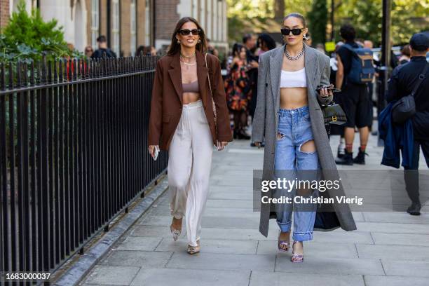 Guest wears brown blazer, cropped top, wide leg pants & a guest wears white cropped top, grey coat, Balenciaga bag, ripped jeans pants, heels outside...