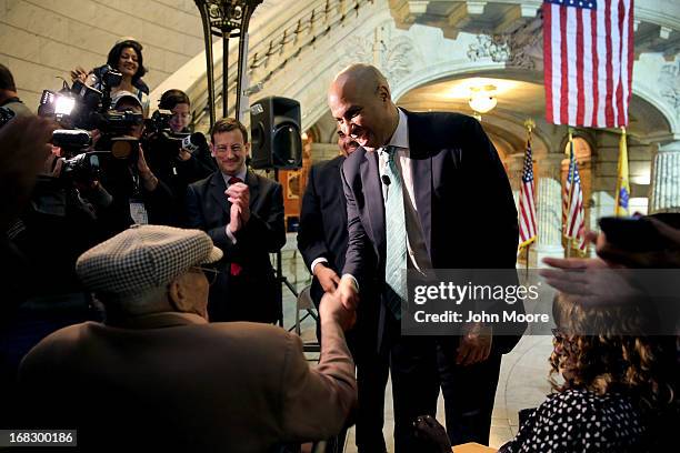 Newark Mayor Cory Booker shakes the hand of 90-year-old WWII veteran Willie Wilkins at the Newark City Hall on May 8, 2013 in Newark, New Jersey....