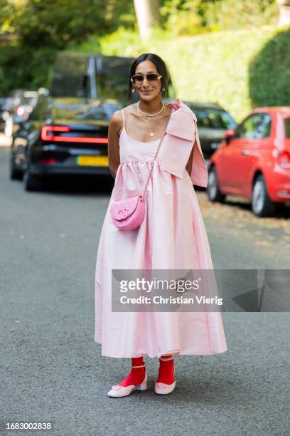 Guest wears pink dress, Chanel bag, red tights, shoes, necklace outside Bora Aksu during London Fashion Week September 2023 on September 15, 2023 in...