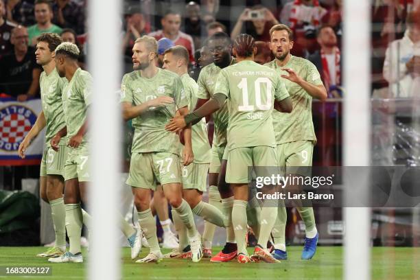 Harry Kane of Bayern Munich celebrates with teammates after scoring the team's first goal during the Bundesliga match between FC Bayern München and...