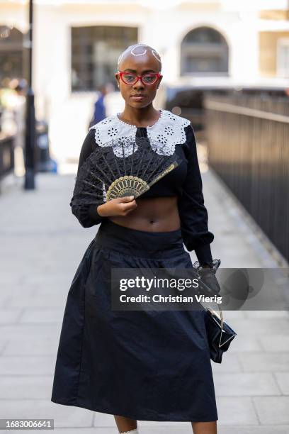 Guest wears black cropped top, skirt, white laced collar outside Bora Aksu during London Fashion Week September 2023 on September 15, 2023 in London,...