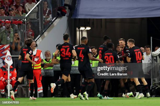 Alex Grimaldo of Bayer Leverkusen celebrates with teammates after scoring the team's first goal to equalise during the Bundesliga match between FC...