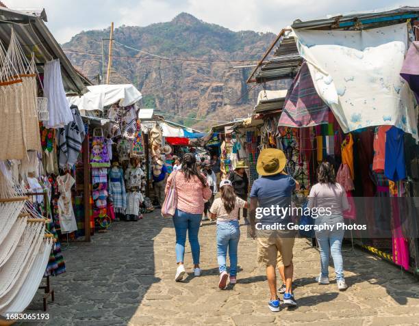 People walking past stalls in the market, Tepoztlan, State of Morelos, Mexico.