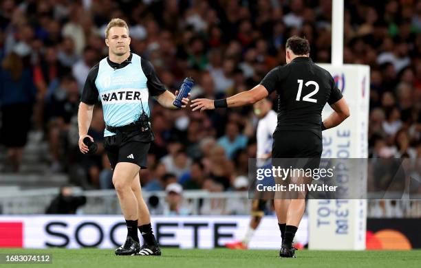 Sam Cane of New Zealand hands David Havili of New Zealand a water bottle during the Rugby World Cup France 2023 match between New Zealand and Namibia...