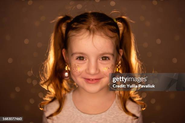 bright, shiny close up portrait of little girl with golden confetti freckles, hair two ponytails. - croatia girls fotografías e imágenes de stock