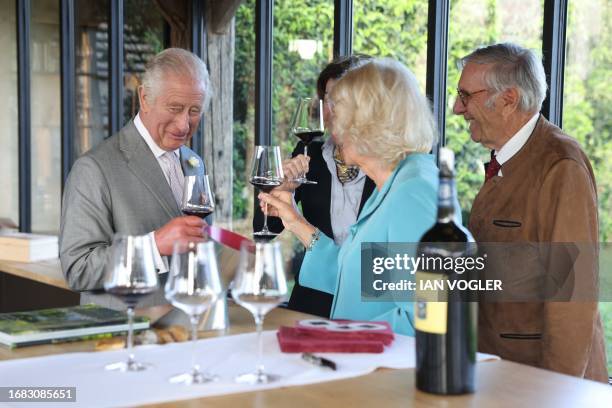 Britain's King Charles III , his wife Queen Camilla and vineyard owner Florence Cathiard toast glasses during a visit to Chateau Smith Haut Lafitte...