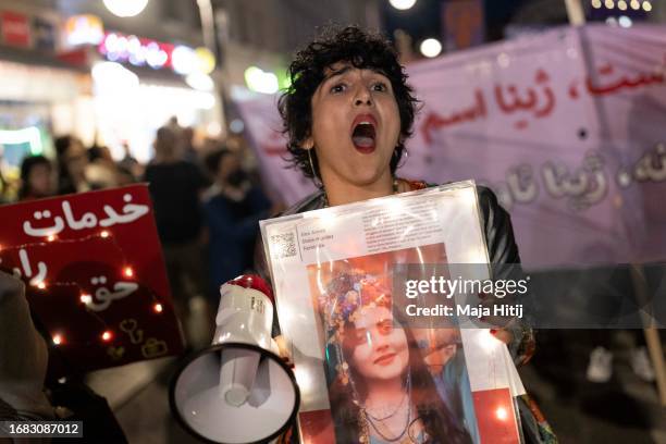 Demonstrator holds a picture of Mahsa Amini while chanting during an evening march to commemorate the first anniversary of the death of Mahsa Amini...