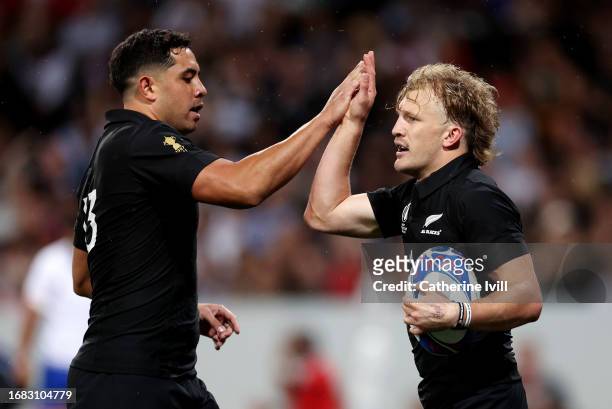 Damian McKenzie of New Zealand celebrates with Anton Lienert-Brown of New Zealand after scoring the team's third try during the Rugby World Cup...