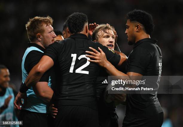 Damian McKenzie of New Zealand celebrates with David Havili and Leicester Fainga'anuku of New Zealand after scoring the team's sixth try during the...