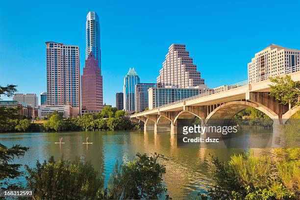 stadt skyline von austin, texas, congress avenue bridge, paddleboarden stehkragen - austin texas stock-fotos und bilder