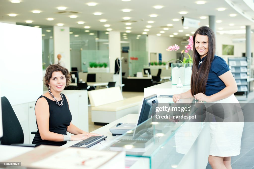 Female receptionist and business woman at reception