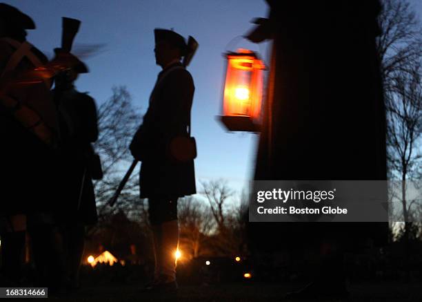 Re-enactors wait in the pre-dawn on the Battle Green for the 238th Anniversary reenactment of the first day of the American War for Independence.