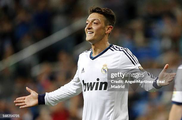 Mesut Ozil of Real Madrid celebrates after scoring his side's third goal during the La Liga match between Real Madrid and Malaga at Estadio Santiago...