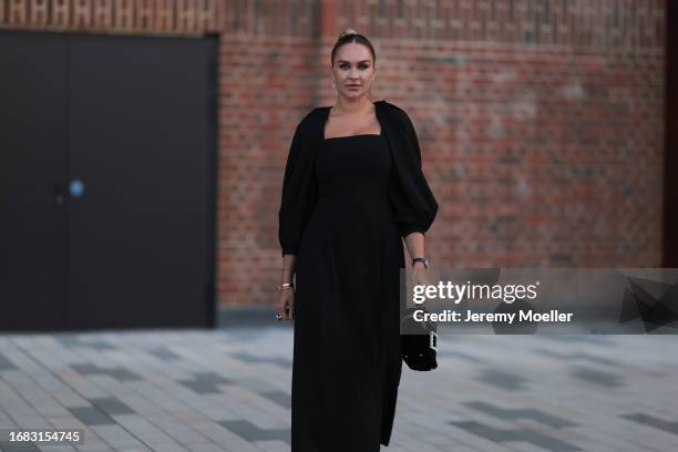 Nina Suess is seen outside the Jaeger LeCoultre cocktail party wearing diamond drop earrings, a black Zara dress with volant sleeves, a Jaeger...