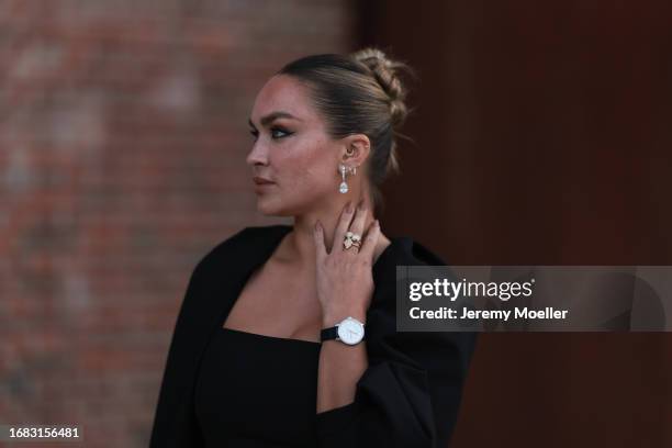 Nina Suess is seen outside the Jaeger LeCoultre cocktail party wearing diamond drop earrings, a black Zara dress with volant sleeves, a Jaeger...