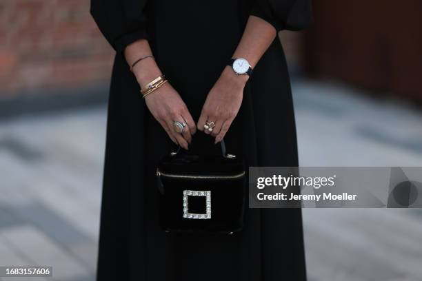 Nina Suess is seen outside the Jaeger LeCoultre cocktail party wearing diamond drop earrings, a black Zara dress with volant sleeves, a Jaeger...