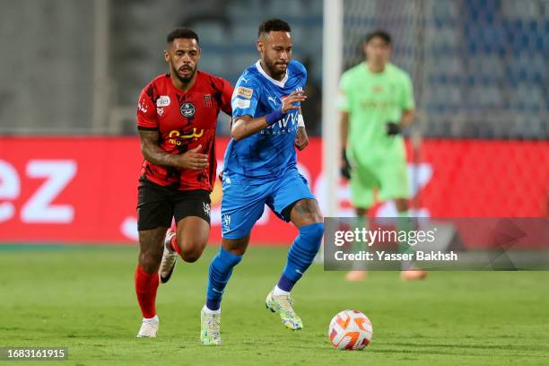 Neymar Jr of Al Hilal on the ball ahead of Andre Gray of Al Riyadh during the match between Al-Hilal and Riyadh at Prince Faisal Bin Fahad on...