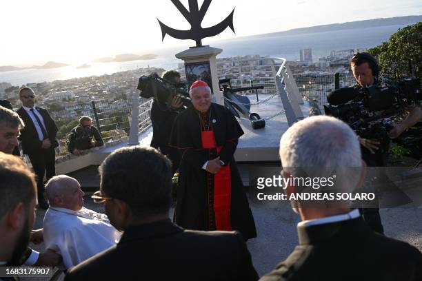 Pope Francis , next to Marseille's Archbishop and Cardinal Jean-Marc Aveline , leaves after a homage at the memorial dedicated to sailors and...