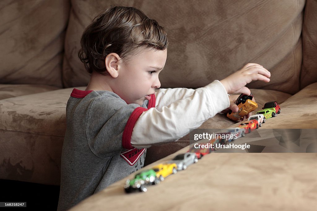 Autista niño jugando con coches de juguete