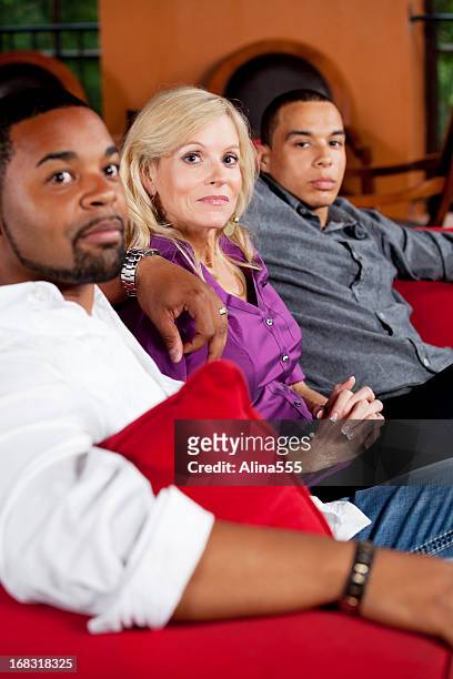 group of friends sitting on the couch - three people on couch stock pictures, royalty-free photos & images