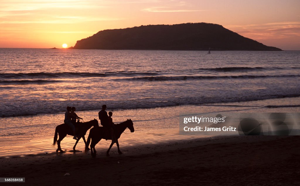 Riding horses on the beach, Mexico