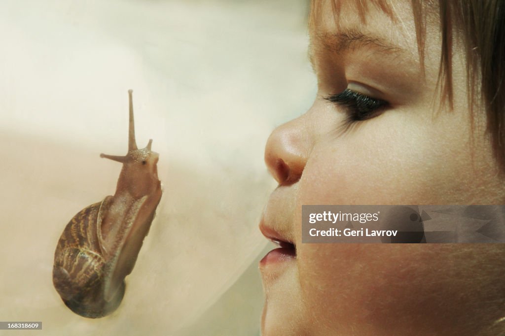 Young girl looking at a snail