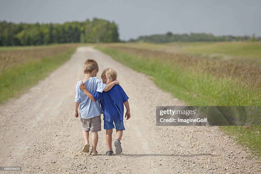 Two Caucasian Boys Walking Down a Country Road