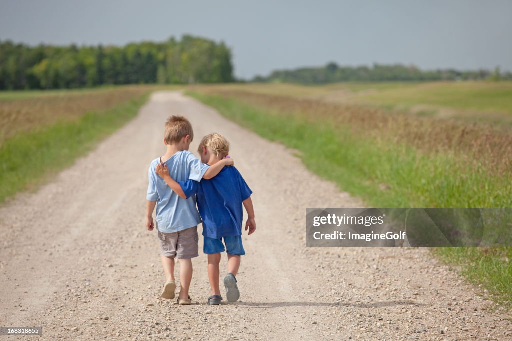 Two Caucasian Boys Walking Down a Country Road