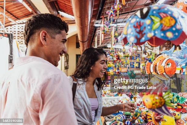 pareja joven elige un juguete para comprar en la tienda de juguetes - cuba lifestyle fotografías e imágenes de stock