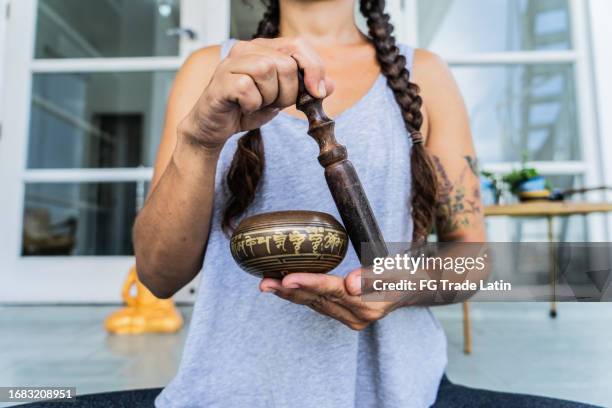 woman playing on tibetan singing bowl - rin gong stock pictures, royalty-free photos & images