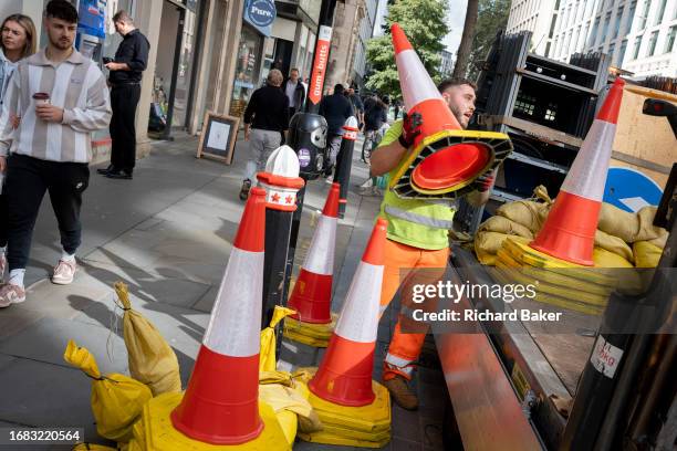 After temporary roadworks, a contractor sorts and stacks road signs and cones on the back of a lorry in the City of London, the capital's finanial...