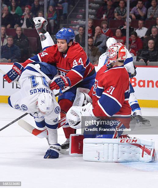 Davis Drewiske of the Montreal Canadiens body checks Steven Stamkos of the Tampa Bay Lightning during the NHL game on April 18, 2013 at the Bell...