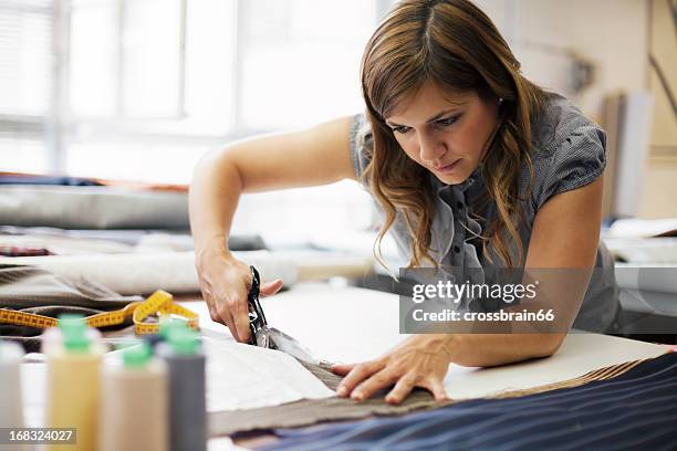 young woman working in clothes manufacture - textielindustrie stockfoto's en -beelden