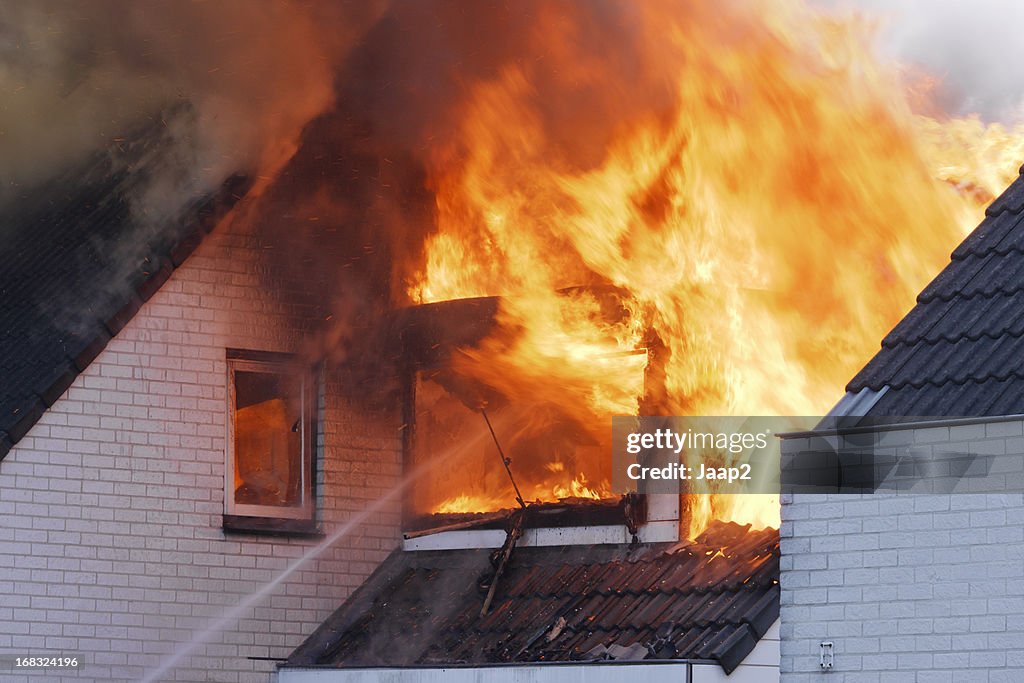 Flames heraus. von white brick wall house on fire